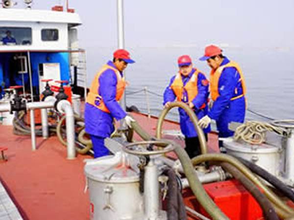 Industrial hoses are put on the ship to handle oil